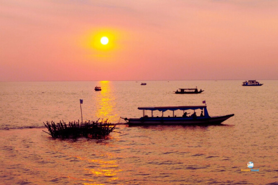 Boat sailing under golden sunset over calm sea in Vietnam – Auasia Travel